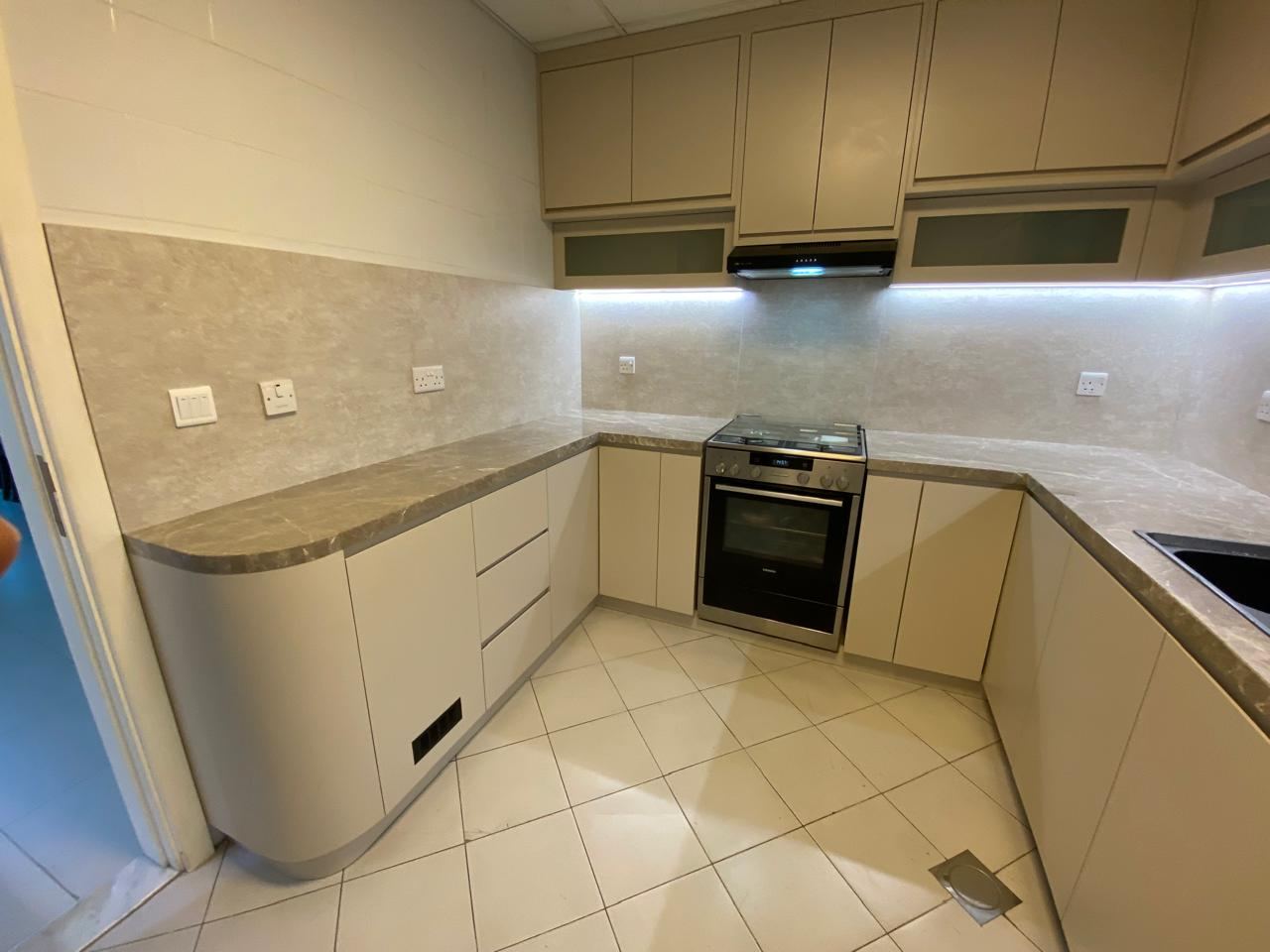 Fitted kitchen with curved end unit and stone-effect worktops