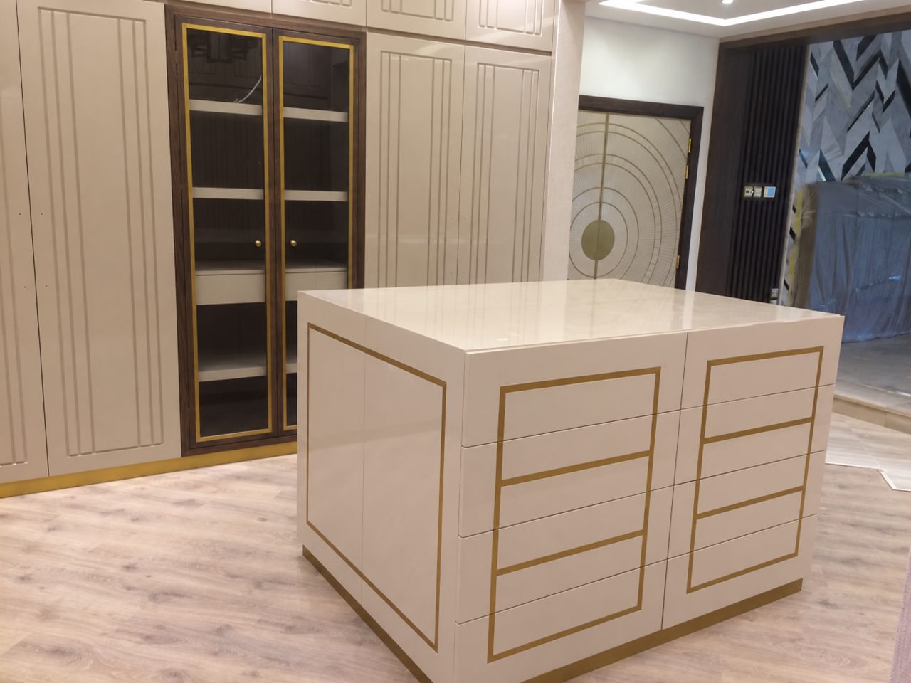 Dressing room island with brass-edged drawers and fitted wardrobes